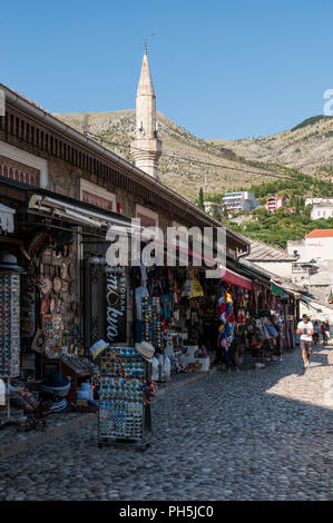 Bosnie : boutiques de la vieille ville de Mostar, avec vue sur le minaret de la Mosquée Tabacica Hadzi-Kurt ou Mosquée construite entre le 16e et 17e siècles Banque D'Images