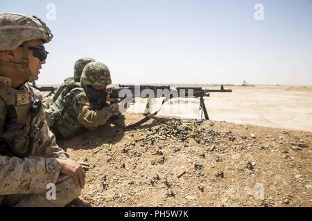 La province d'Helmand, en Afghanistan (27 juin 2018) - Un conseiller du Corps des Marines des États-Unis avec la Force au sud-ouest (TFSW) relève de l'Armée nationale afghane Corps soldats fournissant 215e tir de suppression au cours d'une gamme de tir réel supervisé par les instructeurs de l'ANA et des conseillers avec TFSW Shorabak au camp. C'est la première fois dans l'histoire de l'échelon régional Centre d'entraînement militaire que les militaires de l'ANA ont mené des attaques de tir réel squad avec le soutien de feu de mortiers et mitrailleuses pendant un cycle de préparation opérationnelle. Banque D'Images