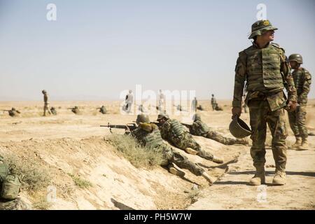 La province d'Helmand, en Afghanistan (27 juin 2018) - L'Armée nationale afghane (ANA) 215e tir de suppression des corps de soldats au cours d'une gamme de tir réel supervisé par les instructeurs de l'ANA et conseillers du Corps des Marines des États-Unis avec la Force au sud-ouest au Camp Shorabak. C'est la première fois dans l'histoire de l'échelon régional Centre d'entraînement militaire que les militaires de l'ANA ont mené des attaques de tir réel squad avec le soutien de feu de mortiers et mitrailleuses pendant un cycle de préparation opérationnelle. Banque D'Images