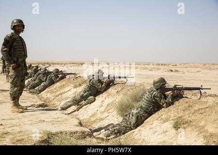 La province d'Helmand, en Afghanistan (27 juin 2018) - Un chef d'escouade de l'Armée nationale afghane observe son environnement avant de coordonner les incendies avant qu'une gamme de tir réel supervisé par les instructeurs de l'ANA et conseillers du Corps des Marines des États-Unis avec la Force au sud-ouest au Camp Shorabak. C'est la première fois dans l'histoire de l'échelon régional Centre d'entraînement militaire que les militaires de l'ANA ont mené des attaques de tir réel squad avec le soutien de feu de mortiers et mitrailleuses pendant un cycle de préparation opérationnelle. Banque D'Images