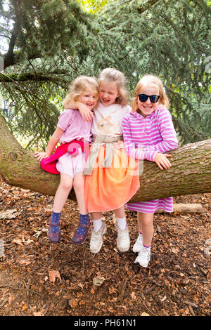 Les filles / jeune fille / enfant / Enfants / enfant / enfants 3 soeurs jouer avec branche d'arbre dans le parc et jardins pendant les vacances à Kew gardens / Royal Botanic garden. London UK Banque D'Images