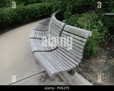 Un banc de parc bois courbé dans un parc public Banque D'Images