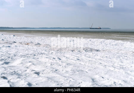 Boues de glace dans la mer d'huile, plate-forme dans la mer d'hiver à l'horizon Banque D'Images