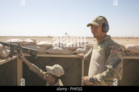 Un entraîneur danois observe les membres de la Force de garde-frontières irakiennes tout en servant d'une gamme de la sécurité au cours de l'exercice de tir réel sur la base aérienne d'Al Asad, l'Iraq, le 24 juin 2018. Cette formation fait partie de la Force opérationnelle interarmées combinée globale - Fonctionnement amélioré la capacité inhérente de résoudre partenaire mission qui se concentre sur la formation pour améliorer la sécurité au sein de la nation. Banque D'Images