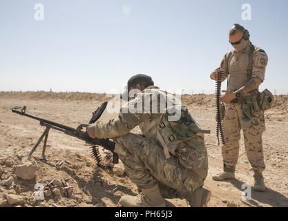 Le Sgt estonien. Ott Joesaar aide un membre de la Force de garde-frontières iraquiennes dans le chargement d'une mitraillette au cours de la réaction rapide de la part d'un exercice de tir réel à la base aérienne d'Al Asad, l'Iraq, le 24 juin 2018. Cette formation fait partie de la Force opérationnelle interarmées combinée globale - Fonctionnement amélioré la capacité inhérente de résoudre partenaire mission qui se concentre sur la formation pour améliorer la sécurité au sein de la nation. Banque D'Images