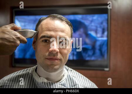 Océan Atlantique (26 juin 2018) Spécialiste de la communication de masse 1re classe Sean blessé, de Westfield, Massachusetts, se couper les cheveux dans le salon de coiffure à bord du porte-avions USS George H. W. Bush (CVN 77). Le navire est en cours d'entraînement de routine des exercices pour maintenir l'état de préparation de l'opérateur. Banque D'Images