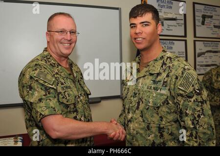 NAVAL BASE KITSAP - BANGOR (26 juillet 2018) maître d'armes de 1re classe Joshua D. Mason reçoit la commande de pièces Le Capitaine Alan Schrader, commandant de la base navale de KItsap (NBK), de leur travail au cours de l'évaluation finale Problème (FEB). Jan est une évaluation d'une installation en matière de sécurité et de gestion des interventions d'urgence à une situation de protection de la force. NBK est la première grande installation de passer l'évaluation. Banque D'Images