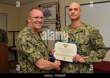 NAVAL BASE KITSAP - BANGOR (26 juillet 2018) maître d'armes de 1re classe Shawn D. Shirley reçoit la Marine et le Marine Corps Médaille d'excellence par le Capitaine Alan Schrader, commandant de la base navale de KItsap (NBK), de leur travail au cours de l'évaluation finale Problème (FEB). Jan est une évaluation d'une installation en matière de sécurité et de gestion des interventions d'urgence à une situation de protection de la force. NBK est la première grande installation de passer l'évaluation. Banque D'Images