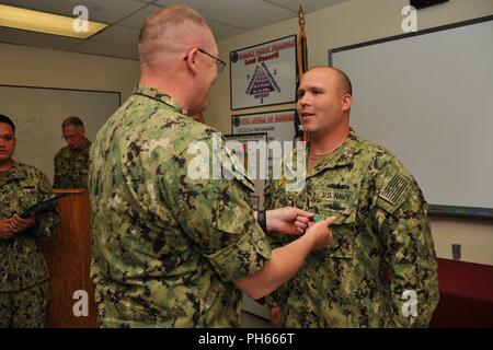 NAVAL BASE KITSAP - BANGOR (26 juillet 2018) maître d'armes de 1re classe Andrew S. Mclaren remporte la Marine et le Marine Corps Médaille d'excellence par le Capitaine Alan Schrader, commandant de la base navale de KItsap (NBK), de leur travail au cours de l'évaluation finale Problème (FEB). Jan est une évaluation d'une installation en matière de sécurité et de gestion des interventions d'urgence à une situation de protection de la force. NBK est la première grande installation de passer l'évaluation. Banque D'Images