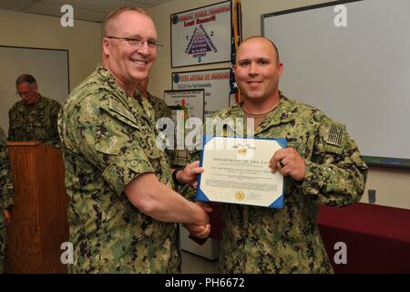 NAVAL BASE KITSAP - BANGOR (26 juillet 2018) maître d'armes de 1re classe Andrew S. Mclaren remporte la Marine et le Marine Corps Médaille d'excellence par le Capitaine Alan Schrader, commandant de la base navale de KItsap (NBK), de leur travail au cours de l'évaluation finale Problème (FEB). Jan est une évaluation d'une installation en matière de sécurité et de gestion des interventions d'urgence à une situation de protection de la force. NBK est la première grande installation de passer l'évaluation. Banque D'Images