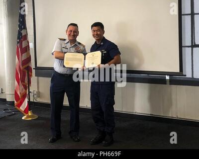 Le capitaine Tony Ceraolo, commandant du Secteur de la Garde côtière de San Francisco, présente le lieutenant Mike Wu et le lieutenant Rachel Thomas (non illustré) avec mention des médailles, le 27 juin 2018, pour leur rôle dans le cadre d'un sauvetage sur Mt. Juin 10, 2018 Whitney. Thomas et Wu a aidé les alpinistes blessés après qu'ils ont chuté, la stabilisation des blessures pendant l'attente de sauvetage par comté d'Inyo et California Highway Patrol. Banque D'Images