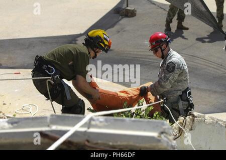 TEL AVIV, ISRAËL - Le Sergent-chef de l'Armée de l'air. Andrew l'amour, non, une recherche et extraction medic du 19e Force de réaction de l'amélioré CBRN Package, fonctionne avec une force de défense israélienne soldat du bataillon Ram Tavor Brigade à sauver une "victime" sur un terrain irrégulier pendant un exercice de formation à la ronde de la seconde journée de United Front VII au Camp Yigael Yadin, 19 juin 2018. La 19ème CERFP contre-trains avec les forces israéliennes et unit combinée, la construction et le renforcement des liens entre les nations unies et des forces. Banque D'Images