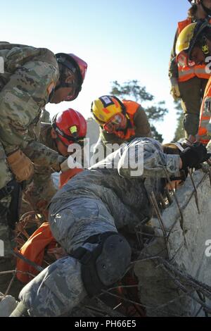 TEL AVIV, ISRAËL - La Garde nationale de l'Indiana à partir de la 19ème Force de réaction renforcée CBRN et de défense israéliennes recherchez et extraction les soldats travaillent pour sauver une victime simulée au cours de l'exercice final de l'unie face à la base de formation de Zikim VII le 20 juin 2018. L'exercice final combiné les jours précédents de la formation avec un exercice réel avec les soldats d'accueil/commande. Banque D'Images