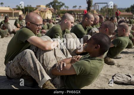 En Recrutement de la Compagnie Bravo, 1er bataillon de formation des recrues, effectuer des craquements lors d'un événement bien sûr confiance à Marine Corps Recruter Depot San Diego, le 25 juin. Les recrues achevé plusieurs exercices dynamiques de préchauffer avant la confiance en soi. Chaque année, plus de 17 000 hommes recrutés dans la région de recrutement de l'Ouest sont formés à MCRD San Diego. La Compagnie Bravo diplômé est prévue pour le 31 août. Banque D'Images