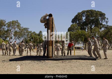 En Recrutement de la Compagnie Bravo, 1er bataillon de formation des recrues, balances un mur lors d'un événement bien sûr confiance à Marine Corps Recruter Depot San Diego, le 25 juin. L'échelle sur le mur, les recrues pratiqué plusieurs arts martiaux Marine Corps techniques du programme. D'autres obstacles dans le cours comprenait le pont de singe, grimper au mur de gratte-ciel et plusieurs autres. Chaque année, plus de 17 000 hommes recrutés dans la région de recrutement de l'Ouest sont formés à MCRD San Diego. La Compagnie Bravo diplômé est prévue pour le 31 août. Banque D'Images