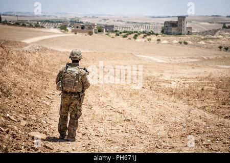 Un soldat américain fournit la sécurité lors d'une patrouille indépendante, coordonnée le long de la ligne de démarcation près d'un village à l'extérieur de Manbij, Syrie, le 26 juin 2018. Les États-Unis ont récemment commencé à effectuer ces patrouilles avec les forces militaires turques, de patrouiller sur les côtés opposés de la ligne de démarcation. Banque D'Images