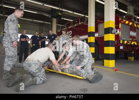 Aviateurs affectés à la 86e Escadron de Génie Civil Services d'urgence en cas d'incendie et de transport pratique immobiliser un patient simulé au cours d'une 86e Conférence sur la formation des intervenants d'urgence CEF Ramstein Air Base, 25 juin 2018. La 86e Groupe médical envoyé 6 membres du personnel à former les pompiers afin de garder des pompiers de la compétences et de renforcer les relations de travail entre la 86e et de l'OMD l'incendie, qui répondent souvent à des urgences médicales ensemble. Banque D'Images