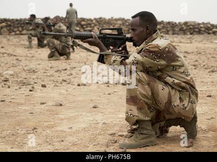 Les membres du bataillon d'intervention rapide, une unité d'intervention de crise de l'armée djiboutienne, prendre une position de tir tout en apprenant des techniques de délimitation d'un site à l'extérieur de la ville de Djibouti, le 25 juin 2018. Les membres de la côte sur une période de cinq semaines de cours couvrant combatives, d'armes, et de combattre en sauvetage. Banque D'Images