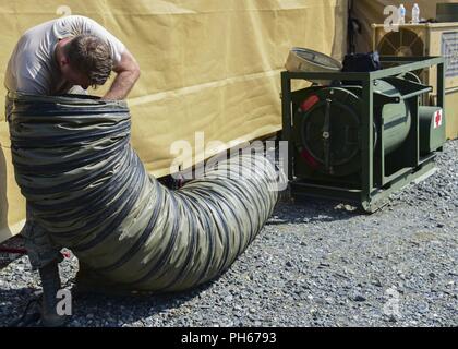 Un corps expéditionnaire Medical Systems assemble des composants de l'exercice d'un membre de la tente à Joint Base Langley-Eustis, Virginie, le 20 juin 2018. Un groupe restreint des aviateurs ont été formés sur la tente d'assemblage avant l'exercice et ont ensuite chargé d'enseignement bénévoles sur les procédures nouvellement appris. Banque D'Images