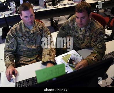 Le sergent-chef de l'US Air Force. Brian Yorke, gauche, le personnel de l'exercice (STAFFEX) 18-4 Joint Personnel Recovery Centre (JPRC) planner, et le Major Rob Arduini, STAFFEX 18-4 planner, tant à partir de la 9e armée de l'air, discuter JPRC options disponibles pour le scénario de l'exercice, le 20 juin 2018, Shaw Air Force Base, L.C. Le STAFFEX les scénario un effort d'assistance humanitaire dans le U.S. Africa Command zone de responsabilité. C'est la quatrième 9 STAFFEX AF a eu lieu depuis novembre 2017 qu'il travaille à la certification en tant qu'un groupe de travail mixte-capable siège à l'Armée de l'air. Banque D'Images