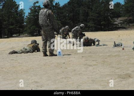 Sous l'œil attentif d'un instructeur, le SPC. Michael McClean, originaire de Westminster, Colorado qui représente le 71e Groupe de munitions (NEM), rampe à sa prochaine position de tir pendant le stress test pousse dans le cadre de la 20e d'armes chimiques, biologiques, radiologiques, nucléaires et explosifs 2018 Commande Concours meilleur guerrier à Joint Base McGuire-Dix-Lakehurst, New Jersey. Ce concours annuel permet de tester les capacités physiques et mentales de ces soldats pour sélectionner le sous-officier et soldat de l'année qui seront en compétition au Commandement des forces américaines à Fort Bragg, N.C. Banque D'Images