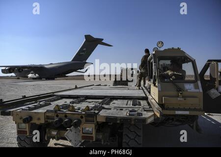 L'armée américaine et de l'antenne de l'Armée de l'air porteurs se préparer à décharger des marchandises d'une U.S. Air Force C-17 Globemaster à un aérodrome de la Coalition dans le nord-est de la Syrie, le 26 juin 2018. Le C-17, affecté à la 816th Escadron de transport aérien expéditionnaire, palettes de marchandises livrées à l'appui des opérations de base et les missions régionales. Banque D'Images