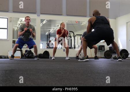 Le Sgt. 1re classe Marcus Wallace, 504e Brigade du renseignement militaire, de Fort Hood, au Texas, mène les soldats lors d'une routine de travail, le 20 juin 2018. Le travail a eu lieu après les heures de service et a pour but d'améliorer la force physique. Banque D'Images