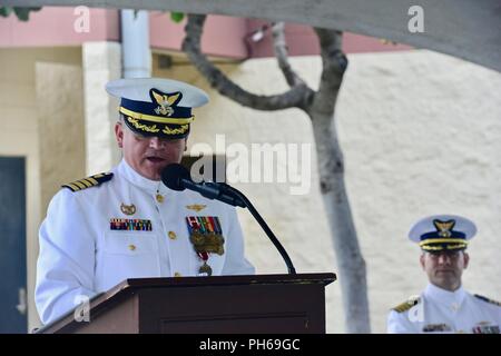 Le Capitaine Ed Sheppard donne aux remarques et se félicite le capitaine Travis Rasmussen, au cours d'une cérémonie de passation de commandement à la base de la Garde côtière de Honolulu, le 28 juin 2018. Sheppard arrière, originaire de New York, va maintenant rejoindre la U.S. Coast Guard Academy personnel à New London, Connecticut Banque D'Images