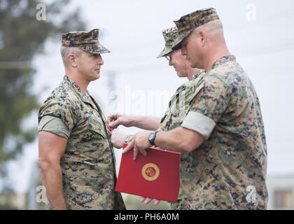 Le Capitaine de vaisseau américain Spencer T. Schoen, gauche, commandant sortant, Domaine Battalion-West FMTB (Formation médicale-W), reçoit une médaille de la Légion du Mérite de l'arrière Adm. Brian S. Pecha, center, U.S. Marine Corps Reserve, chirurgien de la flotte La flotte des États-Unis, au cours d'une cérémonie de passation de commandement au Marine Corps Base Camp Pendleton, en Californie, le 29 juin 2018. Spencer a reçu la médaille de la Légion du mérite pour services exceptionnels et conduite méritoire exceptionnel en tant que commandant du FMTB-W de juin 2016 à juin 2018. Banque D'Images