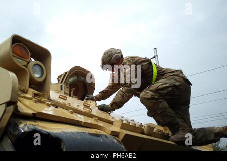 Un soldat affecté au 2e bataillon, 5e régiment de cavalerie, 1st Armored Brigade Combat Team, 1re Division de cavalerie grimpe un M2A3 véhicule de combat Bradley pendant les opérations de chargement ferroviaire à la gare d'Sendreni en Roumanie dans le cadre de détermination de l'Atlantique, un exercice d'entraînement durables entre l'OTAN et les forces américaines, le 27 juin 2018. Les soldats chargés de divers véhicules blindés dont plusieurs M2A3 Bradley de combat, plusieurs M88A2 Hercules armored de dépannage et des dizaines de véhicules à roues pour de futures missions d'entraînement à Galati, Roumanie Zone de formation. Banque D'Images