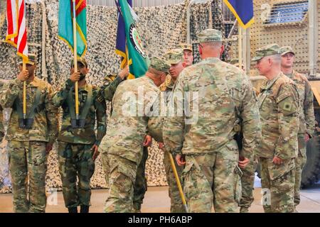 L'AÉRODROME DE KANDAHAR, Afghanistan (30 juin 2018) -- L'ARMÉE AMÉRICAINE Brig. Le général Jeffrey Smiley, nouveau commandant pour former, informer et aider les Command-South, mains la TAAC-Sud commande couleurs pour le Sgt. Le major Anton Hillig, premier chef d'enrôlés TAAC-Sud, le 30 juin 2018, au cours d'une cérémonie de transfert d'autorité à Kandahar, en Afghanistan. Smiley, affecté à la 40e Division d'infanterie, la Garde nationale de Californie, a assumé l'autorité de TAAC-sud de l'armée américaine de Brig. Le général John Lathrop, commandant sortant de TAAC-Sud, au cours de la cérémonie. Banque D'Images