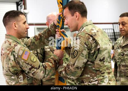 L'adresse au tir de l'armée américaine Commande de l'unité Le Sgt. Le major Jason Levy accepte les couleurs du bataillon de son nouveau commandant, le Lieutenant-colonel Lawrence Harris au cours d'une cérémonie de passation de commandement à Fort Benning, Géorgie le 26 juin. Banque D'Images