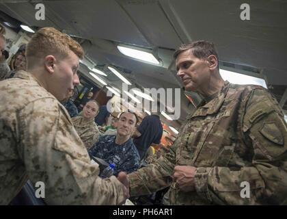 Le Golfe Arabique (22 juin 2018) l'armée américaine le général Joseph Votel, commandant du Commandement central des États-Unis, pièces de Corps des Marines américains Le Cpl. Colin canton après restauration avec marins et Marines sur le gâchis ponts de la classe Wasp-navire d'assaut amphibie USS Iwo Jima (DG 7). Iwo Jima, homeported à Mayport, en Floride, est le déploiement de la 5e flotte américaine zone d'opérations à l'appui d'opérations de sécurité maritime de rassurer les alliés et partenaires, et de préserver la liberté de navigation et la libre circulation du commerce dans la région. Banque D'Images