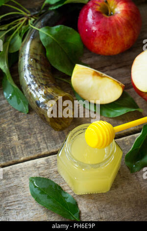 Contexte de Rosh Hashanah (le Nouvel an juif). Symboles de fête traditionnel - shofar, miel et pomme sur une table en bois de cuisine. Banque D'Images