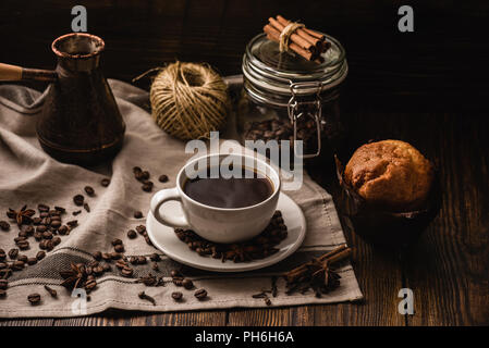 Tasse de café sur la nappe avec Cupcake et différentes épices. Banque D'Images