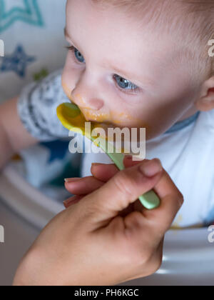 Blue Eyed baby boy eating lunch at home Banque D'Images