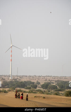 Les femmes nomades dans le désert de Thar avec wind turbine à l'arrière-plan, Rajasthan, Inde Banque D'Images