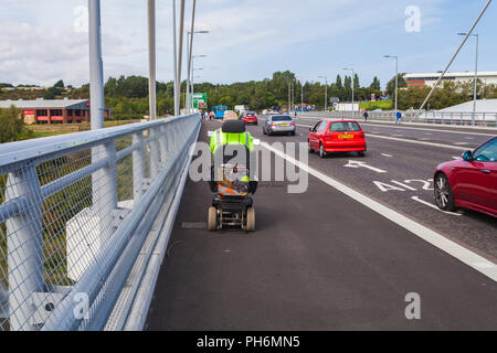 Un homme sur un scooter de mobilité et des voitures à l'aide de la flèche nord du pont traversant la rivière à Sunderland d'usure,Angleterre,UK Banque D'Images