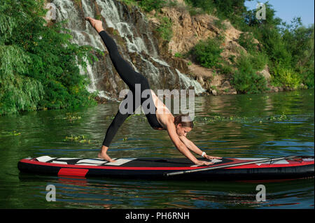 Jeune femme sportive remise en forme faire sur une carte dotée de pagayer sur le lac, la formation d'un mode de vie sain Banque D'Images