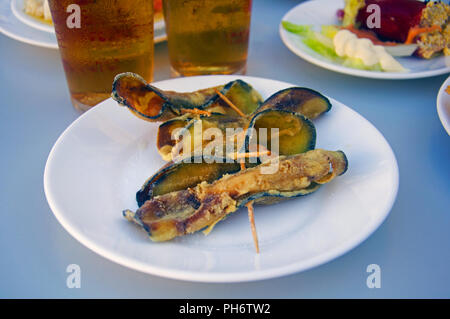 Aubergines frites roulées avec les crevettes à l'intérieur, deux bières et d'autres plaques Banque D'Images