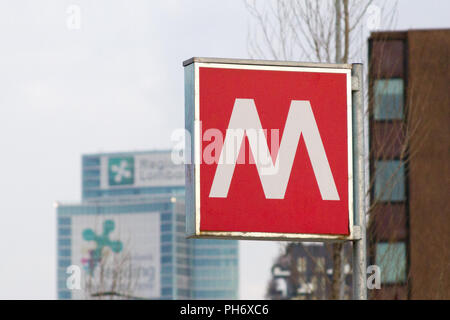 Milano, Italie. 2018/8/2. Un signe d'un 'M' de la station de métro. Gratte-ciel en arrière-plan. Banque D'Images