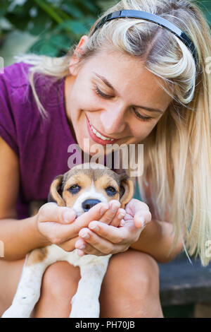 Happy blonde woman cuddling avec mignon chiot beagle. L'amour pur Banque D'Images