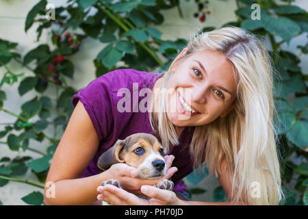 Happy blonde woman cuddling avec mignon chiot beagle. L'amour pur Banque D'Images
