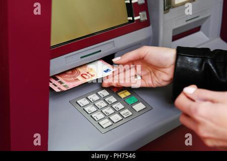 Femme retirer de l'argent de l'ATM Banque D'Images