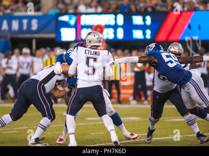 31 août 2018 - East Rutherford, New Jersey, États-Unis - New England Patriots quarterback Danny Etling (5) reçoit la pression de New York Giants secondeur Lorenzo Carter (59) lors d'un match pré-saison entre les New England Patriots et les Giants de New York au Stade MetLife à East Rutherford, New Jersey. Duncan Williams/CSM Banque D'Images