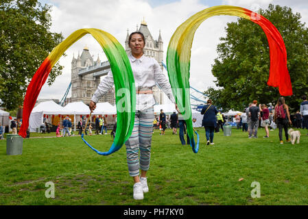 Londres, Royaume-Uni. 31 août 2018. Une femme chinoise danse ruban montre le jour de l'ouverture des trois jours du Festival des aliments chinois à Potters Fields Park à côté de l'Hôtel de Ville. Ainsi que de la nourriture et des boissons provenant de différentes régions de la Chine pour les visiteurs fraîchement préparés à essayer, il y a des démonstrations culinaires et des présentations par le Royaume-Uni de l'Association de la Culture Han. Crédit : Stephen Chung / Alamy Live News Banque D'Images