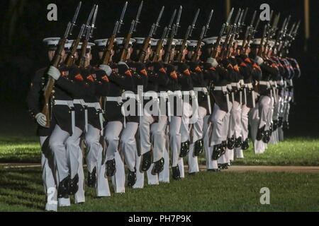 Avec Marine Corps des Marines américains sur mars silencieuse de la parade de pilotage au cours d'un défilé vendredi soir chez Marine Barracks Washington D.C., le 29 juin 2018. L'invité d'honneur pour la cérémonie était le sous-secrétaire de la Marine, Thomas B. Modly, et l'accueil a été le Commandant adjoint du Corps des Marines, le général Glenn M. Walters. Banque D'Images