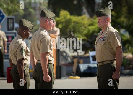 Marine Corps, Sgt. Le major Terrence C. Witcomb, gauche, le sergent-major de la 1 Division de marines (MARDIV), le Major-général Eric M. Smith, milieu, le général commandant du 1er MARDIV, et le Colonel Christopher S. Dowling, droit, le chef d'état-major du 1er MARDIV, stand à l'attention durant la retraite de Dowling cérémonie le Marine Corps Base Camp Pendleton, en Californie, le 29 juin 2018. La cérémonie a eu lieu en l'honneur de Dowling a 34 ans de service méritoire. Banque D'Images