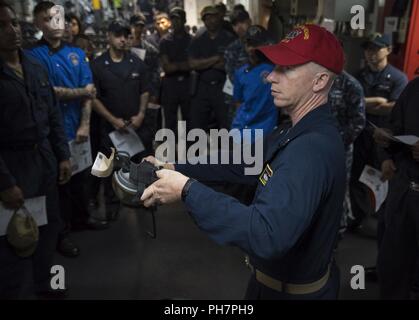 SAN DIEGO (26 juin 2018) Chef Spécialiste culinaire Anthony Hooper décrit les applications d'un MCU-2P masque à gaz au cours d'une d'armes chimiques, biologiques et radiologiques (CBR) exercice de formation à bord du navire d'assaut amphibie USS Bonhomme Richard (DG 6). Bonhomme Richard est en ce moment à son port d'attache de San Diego, la préparation pour un prochain déploiement prévu. Banque D'Images