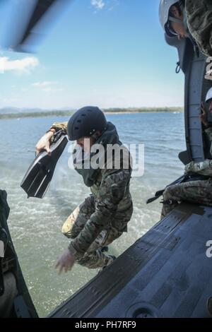 Un soldat de l'armée américaine, attribué à 10e Groupe des forces spéciales (Airborne), saute d'un hélicoptère UH-60 Blackhawk dans Chatfield réservoir pendant un événement de formation helo-cast de Littleton, Colorado, Jun. 29, 2018. L'un des objectifs accompli avec cet événement de formation était de renforcer leur capacité d'attaque de l'air ainsi que la mer. Banque D'Images